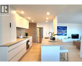 A modern kitchen with white cabinets and a central island.