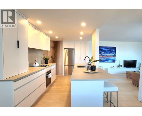 A modern kitchen with white cabinets and a central island.