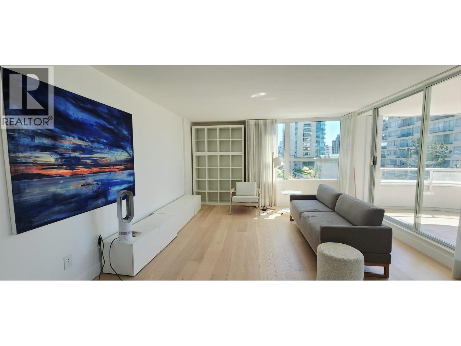 A living room with a large painting on the wall and a couch.