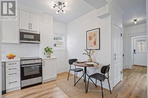 A kitchen with white cabinets and a dining table set for two.