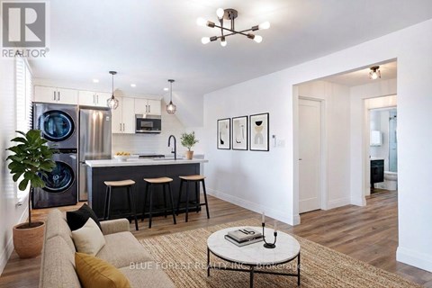 A modern kitchen with a bar and a living room area.