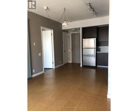 A spacious kitchen with a refrigerator, cabinets, and a countertop.