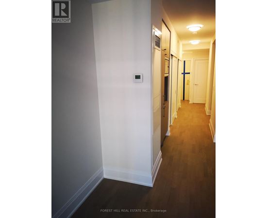 A hallway with wood floors and white walls.