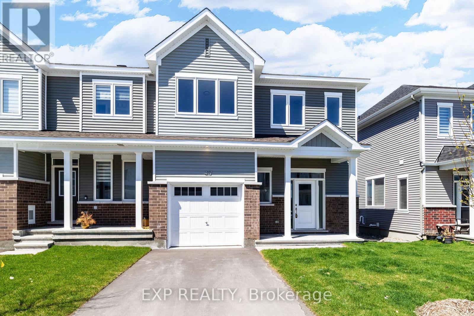 A house with a grey and white exterior and a white garage door.