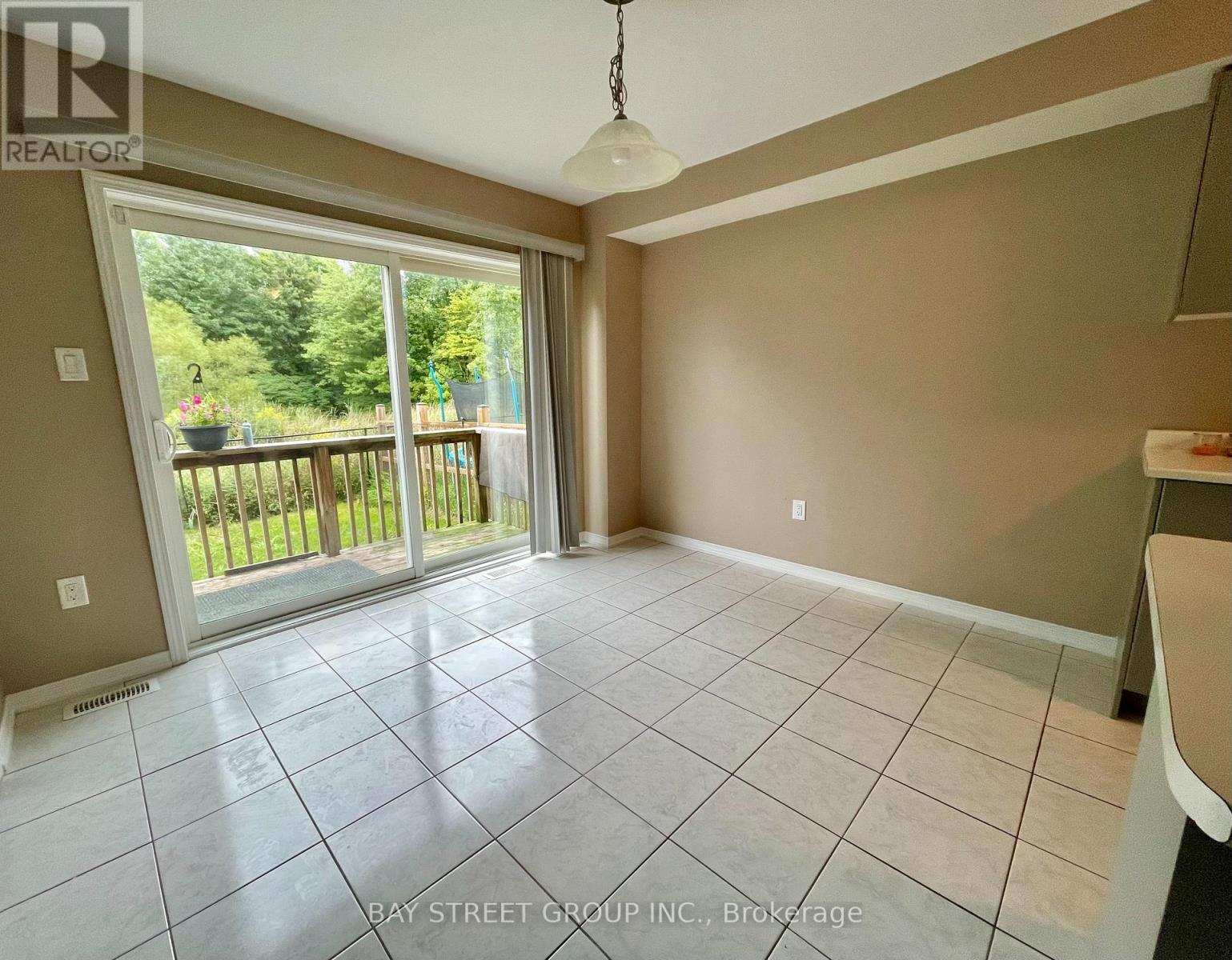 A spacious room with a sliding glass door leading to a deck.