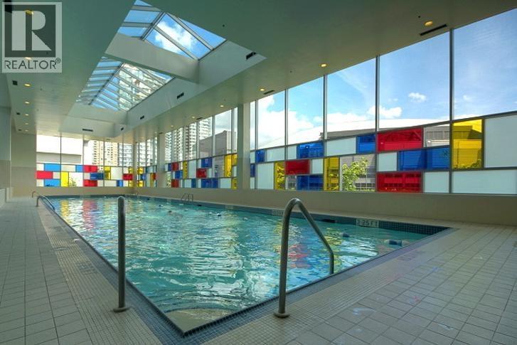 A large indoor swimming pool with a skylight above it.