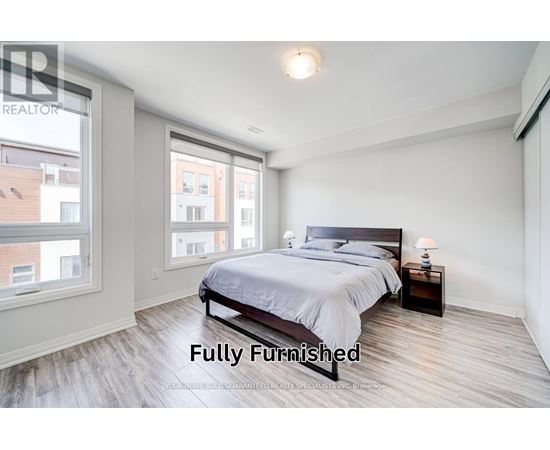 A bedroom with a large bed and a window overlooking a cityscape.