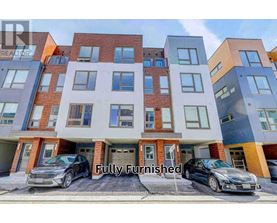 A modern multi-story apartment building with cars parked in front.