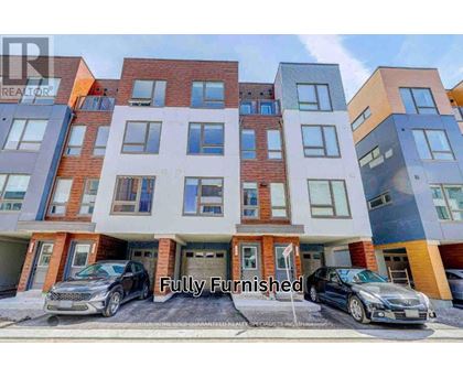 A modern multi-story apartment building with cars parked in front.