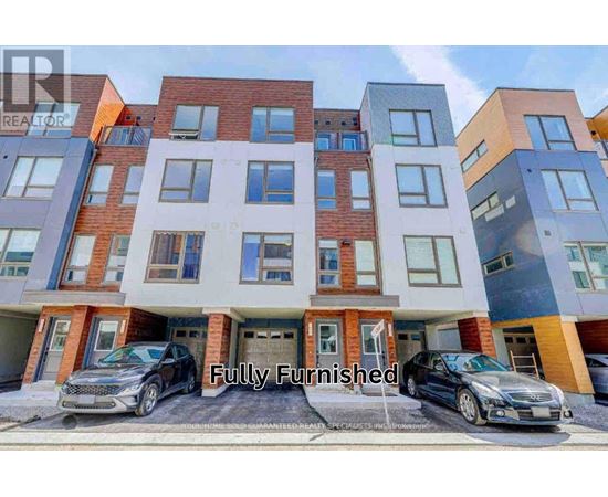 A modern multi-story apartment building with cars parked in front.