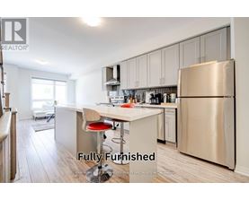 A fully furnished kitchen with a refrigerator, stove, and bar stools.