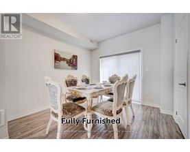 A dining room with a white table and chairs.