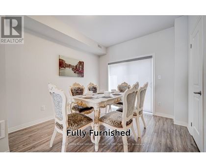 A dining room with a white table and chairs.
