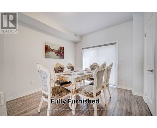A dining room with a white table and chairs.