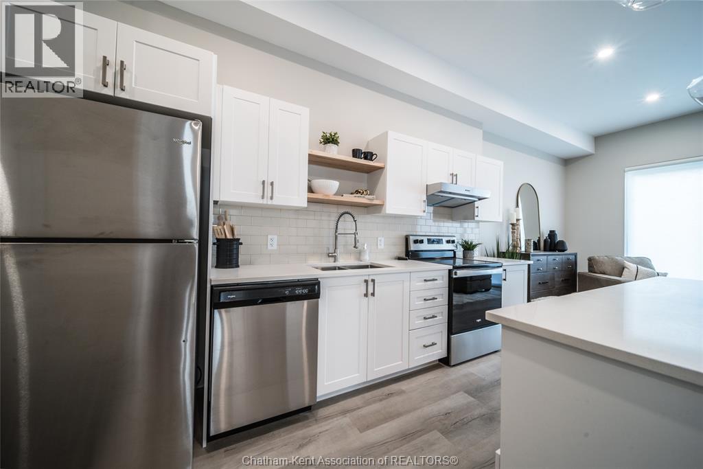 A modern kitchen with white cabinets and stainless steel appliances.