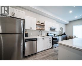 A modern kitchen with white cabinets and stainless steel appliances.