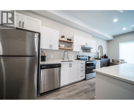 A modern kitchen with white cabinets and stainless steel appliances.
