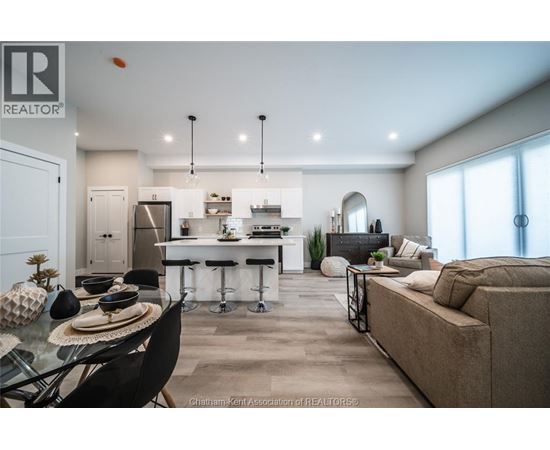 A modern kitchen and living room with a dining table and chairs.