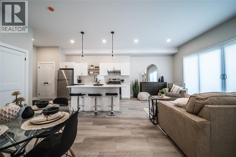 A modern kitchen and living room with a dining table and chairs.