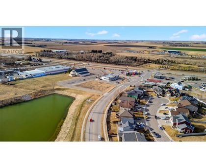 A bird's eye view of a small town with a lake and a road curving around it.