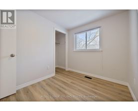 A room with a door and a window with a view of trees.