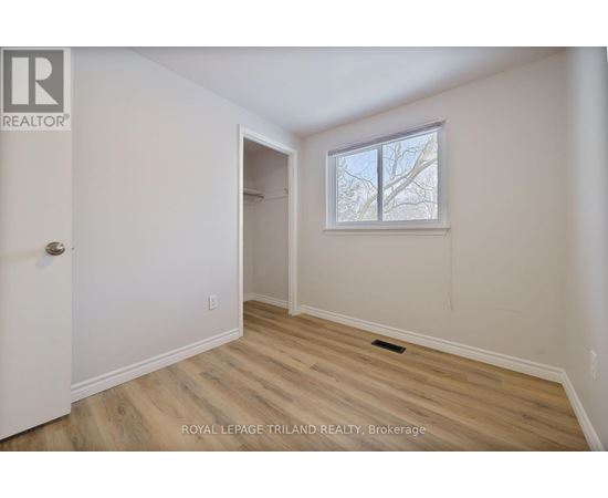 A room with a door and a window with a view of trees.