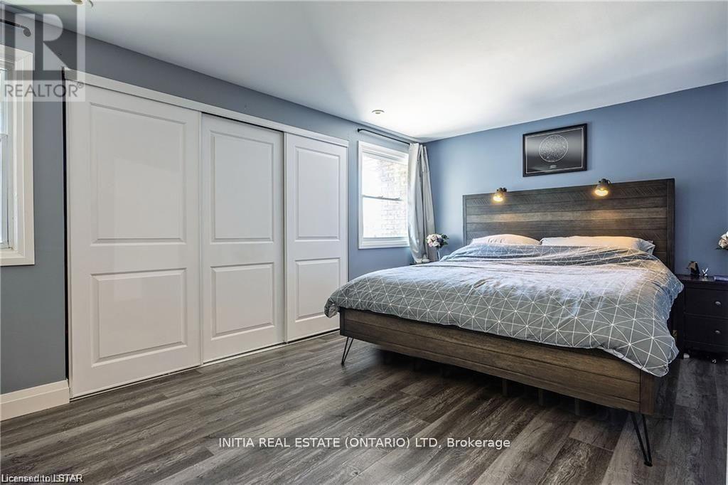 A bedroom with a bed, nightstand, and two doors.
