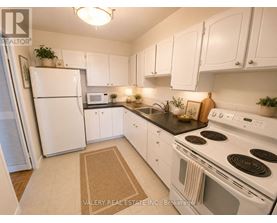 A kitchen with white appliances and cabinets.