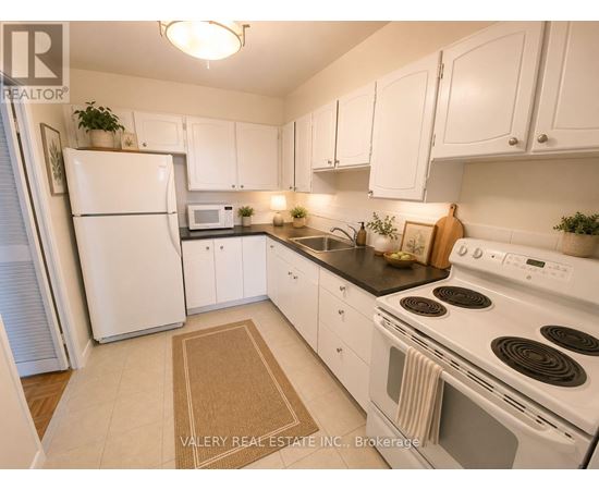 A kitchen with white appliances and cabinets.