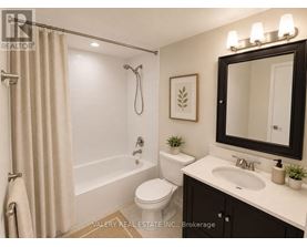 A bathroom with a toilet, sink, and shower.
