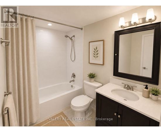 A bathroom with a toilet, sink, and shower.