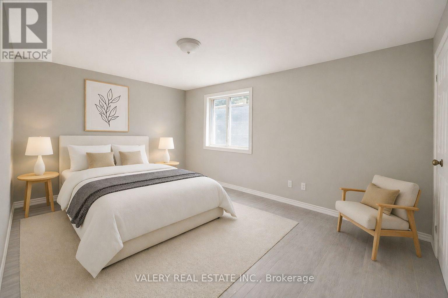 A bedroom with a bed, two lamps, a chair, and a picture on the wall.