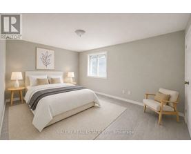 A bedroom with a bed, two lamps, a chair, and a picture on the wall.