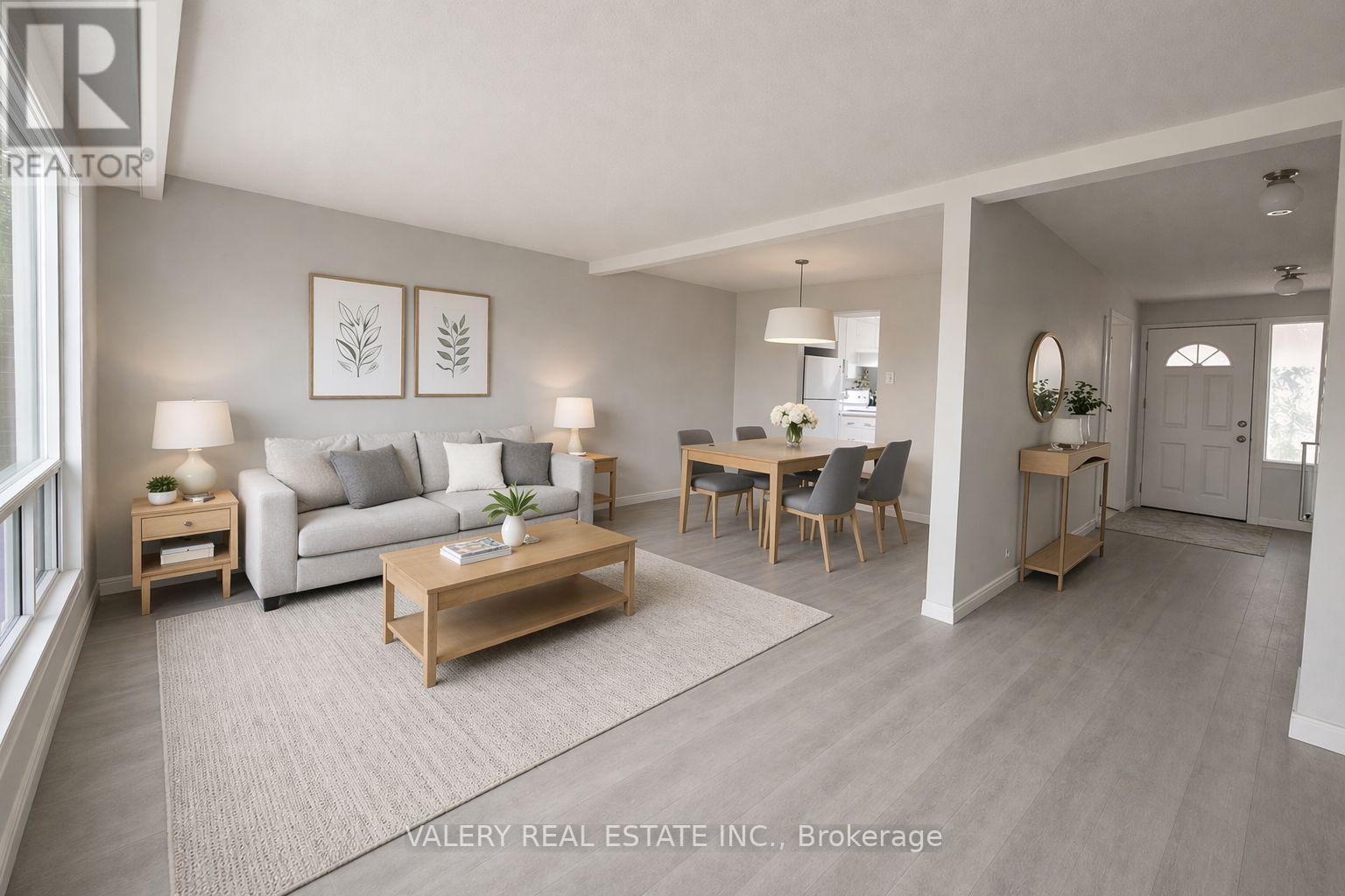 A living room with a couch, coffee table, and chairs.