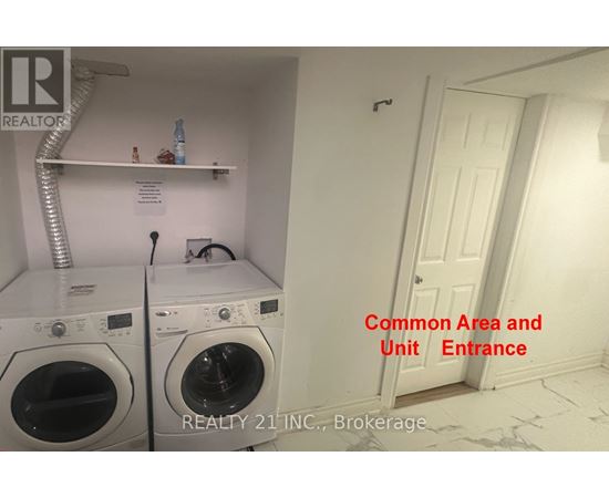 A laundry room with a washer and dryer and a doorway leading to another room.
