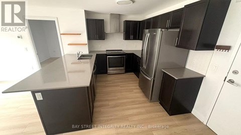 A kitchen with black cabinets and a white countertop.