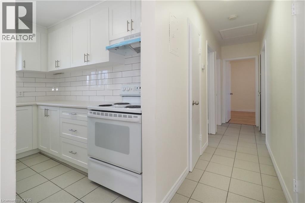 A white kitchen with a white oven and white cabinets.