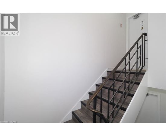 A staircase with a metal railing and wooden steps.