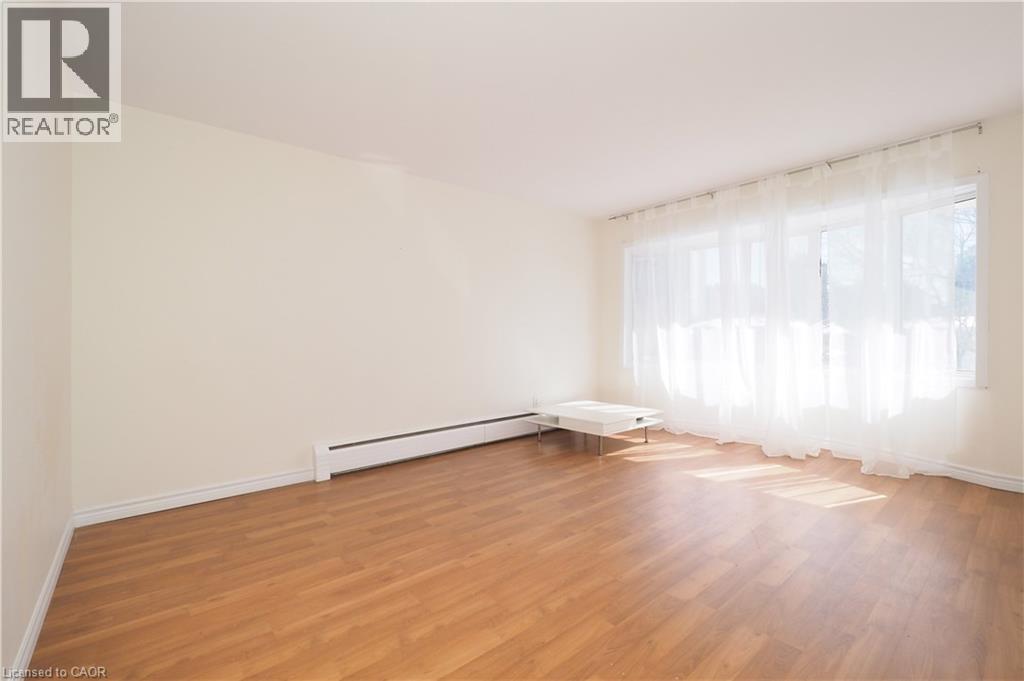 A room with wooden floors and a window with curtains.