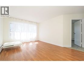 A bedroom with a bed and a wooden floor.