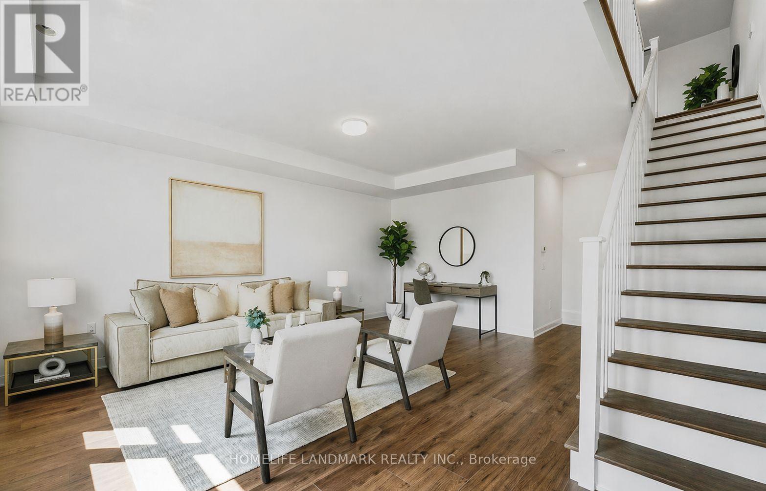 A living room with a white couch, a grey chair, and a wooden floor.