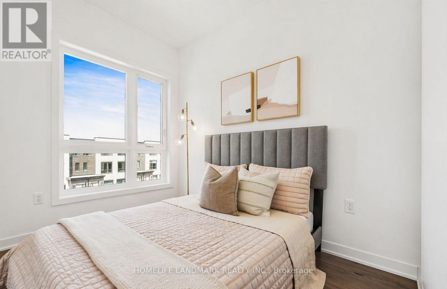 A bedroom with a large bed and a window overlooking a cityscape.
