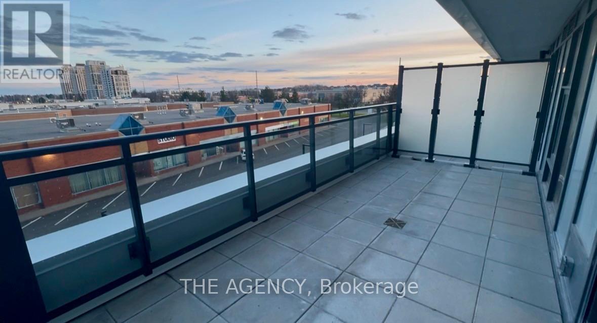 A balcony with a glass railing and a view of the city.