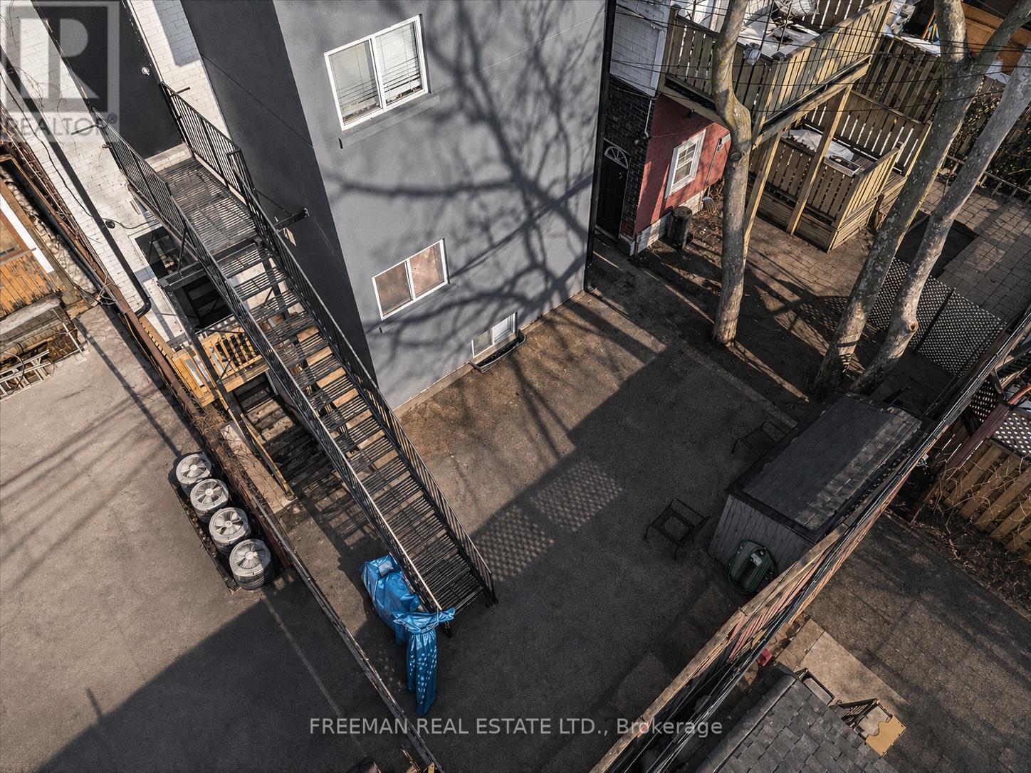 A person is standing on a fire escape with a blue tarp on it.