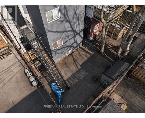 A person is standing on a fire escape with a blue tarp on it.