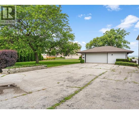 A large, empty driveway leads to a garage with a house in the background.