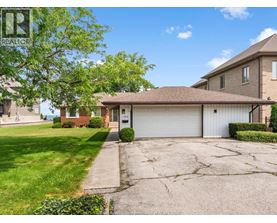 A house with a garage and a tree in front.