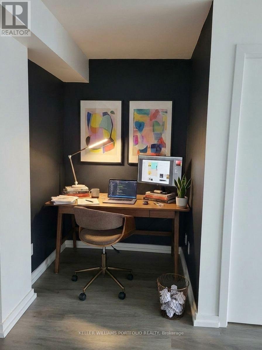 A home office with a desk, chair, and two paintings on the wall.