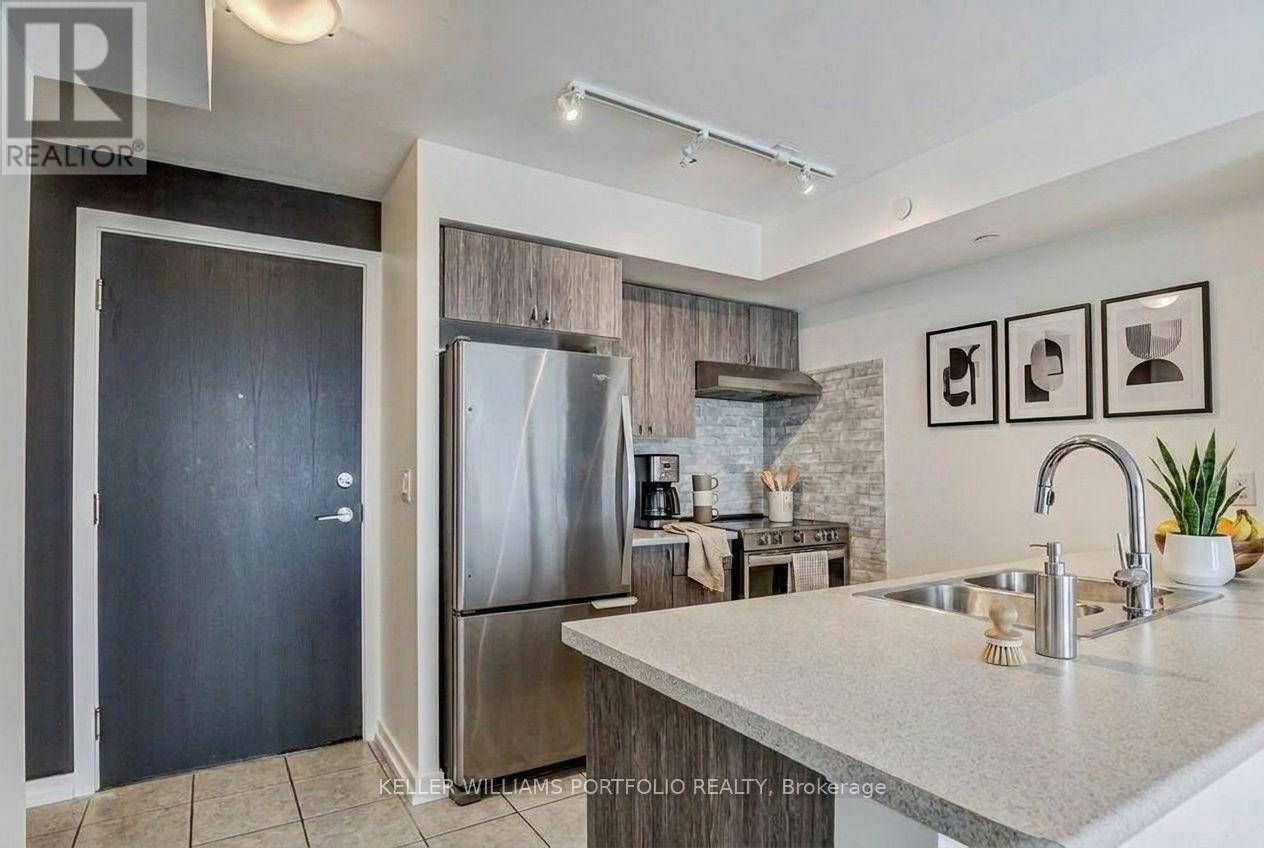 A modern kitchen with a sink, refrigerator, and a countertop.