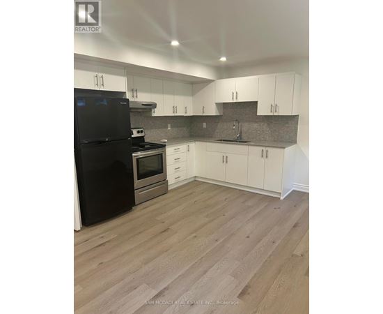 A kitchen with black appliances and white cabinets.